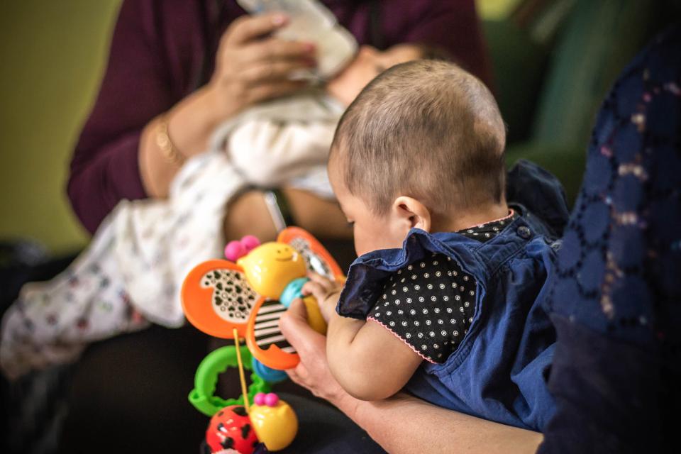 Women feeding and playing with babies