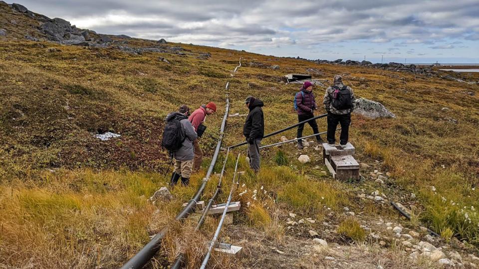 Team examining pipes in Alaska