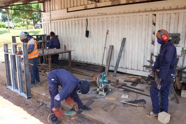 Workers trying to keep social distance during metal fabrication