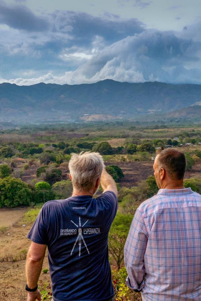 Two men looking at the land before them